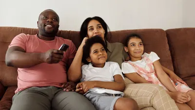 Família assistindo TV juntos na sala